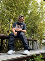 Pantalón negro de gabardina, corte ancho tipo carpenter, con costuras blancas contrastantes.