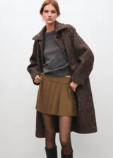 Minifalda plisada de corte cruzado con tira lateral y hebilla ajustable.