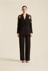 Pantalón negro de mujer con silueta elegante y corte recto, diseñado con amplitud y caída natural para estilizar la figura.