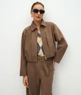 Campera corta de algodón con felpa, diseño tipo baloné con cuello clásico y cierre frontal de cremallera metálica. Presenta un corte holgado y estructura uniforme.