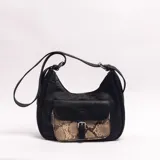 Bandolera de cuero sintético negro con bolsillo frontal con solapa en cuerina con estampado animal print tipo serpiente y cierre con hebilla. Incluye correa ajustable para el hombro y cierre superior.
