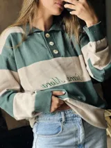 Sweater de punto con cuello polo y botones, a rayas horizontales color marrón y beige.