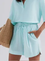 Short de cintura alta con elástico y cordón ajustable, confeccionado en tela ligera con textura, de corte holgado y ruedo redondeado.