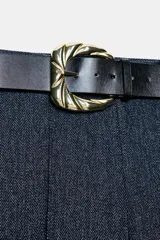 Pantalón de tiro alto con diseño de espiga, corte recto y nervio marcado en el frente. Incluye un cinturón ancho con hebilla metálica dorada y cierre lateral con cremallera oculta.