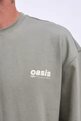 Remera de algodón color verde oliva, corte oversize, con cuello redondo y un pequeño logo bordado en el pecho.