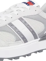 Zapatillas Tommy Jeans blancas y grises con detalles en rojo y azul. Presentan el logo de Tommy Jeans en el lateral y suela dentada. Confeccionadas con poliéster reciclado.