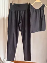 Pantalón slim negro de tiro alto confeccionado en lycra de algodón, con faja ancha de sostén y bolsillos delanteros y traseros.