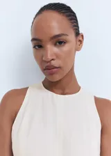Vestido midi de corte evasé, sin mangas, con cuello caja y cierre posterior de cremallera y botón.