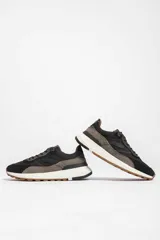 Zapatillas deportivas color crema con detalles en beige, negro y blanco.