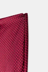 Falda midi de tiro medio confeccionada en tejido satinado con estampado de lunares. Presenta un diseño envolvente con detalle de volante lateral y cierre posterior con cremallera oculta.