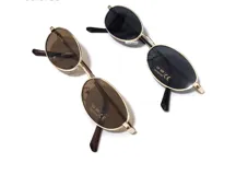 Lentes de sol con montura metálica dorada y cristales marrones ovalados.