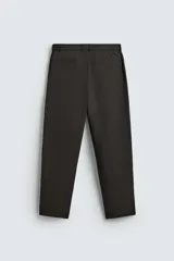 Pantalón de corte regular fit, color negro, confeccionado en tejido elástico. Presenta cintura elástica, cierre frontal con cremallera y botón, bolsillos laterales y bolsillos traseros de vivo.