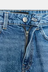 Jeans de tiro alto con corte mom fit, diseño de cinco bolsillos y detalle de raya planchada frontal. Cierre frontal con cremallera y botón.