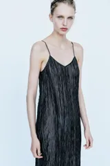Vestido midi negro confeccionado en mezcla de viscosa con tejido satinado y efecto arrugado. Presenta escote en pico, tirantes finos ajustables, bajo con aplicación a tono y acabados deshilachados.