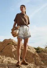 Short de tiro alto color blanco con estampado de palmeras y aves en tonos grises y azules.