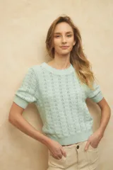 Top tramado color crudo, de manga corta, cuello redondo y elástico en la cintura y mangas.