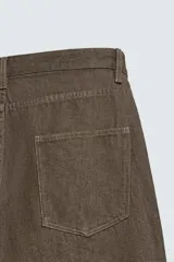 Pantalón de corte regular fit confeccionado en tejido ligero de algodón color marrón. Presenta diseño clásico de cinco bolsillos, cierre frontal con cremallera y botón metálico.