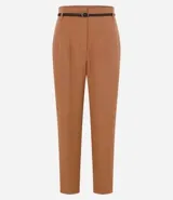 Pantalón de sastrería corte carrot, color beige, con cintura alta, pinzas frontales y cinturón fino incorporado con hebilla metálica.