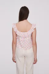 Blusa de algodón con estampado geométrico en tonos rosado y blanco, diseño holgado con escote bote y detalle de volados en los hombros.