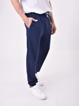 Pantalón de jogging azul marino con cintura elástica y cordón ajustable, bolsillos laterales y puños elásticos en los tobillos.