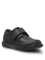 Zapato de cuero negro con textura granulada, diseño de punta redonda y ajuste mediante una tira de velcro. Cuenta con una suela de goma EVA que proporciona flexibilidad y aislamiento térmico.