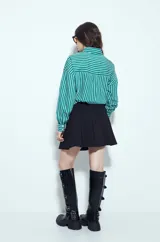 Minifalda tableada de color negro, con diseño de tablas anchas que aportan volumen y movimiento. Presenta un corte estructurado y un calce cómodo.