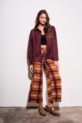 Pantalón de tiro medio y calce recto, confeccionado en poliéster con estampado de cuadros escoceses en tonos burdeos, mostaza, verde oliva y rosado.