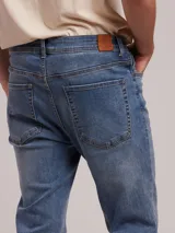 Jean de corte recto y tiro medio, confeccionado en denim con efecto lavado desgastado en tono gris oscuro.