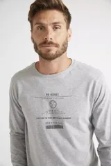 Remera de manga larga color gris melange, con cuello redondo y estampa frontal con diseño gráfico y texto.