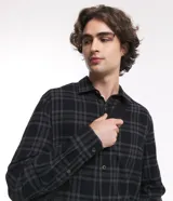 Camisa masculina de franela con estampado de cuadros, corte relaxed, cuello inglés, mangas largas y botones matizados.