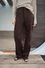 Pantalón de tiro alto confeccionado en tejido con efecto ante, de corte recto y diseño minimalista con trabillas en la cintura y cierre frontal con cremallera y gancho metálico.