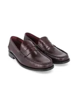 Mocasines de cuero en color bordó con diseño clásico tipo penny loafer, costuras visibles en el empeine y suela plana de goma.