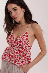 Blusa beige con estampado animal print negro, breteles finos y corte peplum.