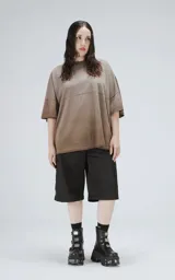 Remera de manga corta con calce extra oversize, color marrón chocolate con efecto gastado/deslavado. Presenta un corte con recortes horizontales en el frente y la espalda, y cuello redondo con terminación deshilachada.