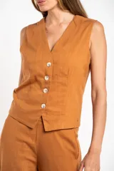 Chaleco de corte sastre con escote en V y cierre frontal de botones. Presenta un diseño sin mangas, entallado al cuerpo, confeccionado en una mezcla de lino y viscosa.