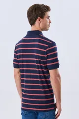 Remera polo de manga corta con diseño de rayas horizontales en color azul marino y rosado. Cuenta con cuello camisero, cierre frontal con botones y calce clásico.