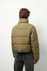 Campera puffer corta color beige de nylon, con cuello alto, cierre frontal y bolsillos laterales con cierre.