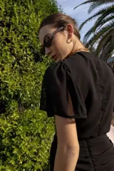 Top marrón con lunares blancos, escote en V, mangas cortas amplias y lazo central.