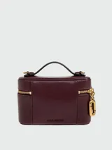 Cartera tipo vanity bag Marc Jacobs modelo The Pop J Marc E/W, color bordó, de diseño estructurado con cierre perimetral de cremallera dorada y herraje metálico distintivo de la marca en la parte frontal. Cuenta con asa superior corta.