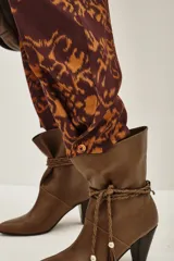 Pantalon de corte recto con estampado tipo ikat en tonos marrón y ocre, con cintura alta y bolsillos laterales.