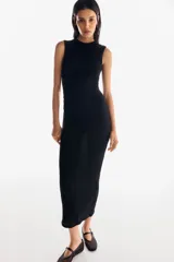 Vestido maxi negro sin mangas, de corte ajustado, con escote redondo y detalle de frunces drapeados en el lateral. El tejido presenta una textura sutilmente arrugada o gofrada.