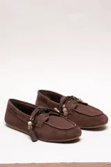 Mocasín estilo náutico de gamuza marrón, con cordones de cuero, borla decorativa y cuentas de colores en el empeine.