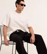 Remera de corte boxy con cuello redondo y mangas cortas, confeccionada en tejido de malla pesada con textura gomosa.