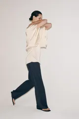 Top fluido de manga corta de Zara Woman Collection, confeccionado en hilatura de viscosa de color crudo. Cuenta con cuello barco, bajo recto y cierre en la espalda con pequeña abertura y botón.