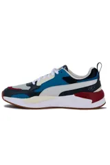 Championes deportivos Puma X-Ray en combinación de azul, gris y negro, con detalles en amarillo flúor y suela blanca y azul.