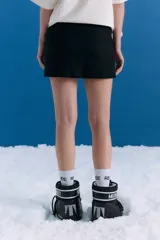 Minifalda de bengalina lisa con tiro medio, cintura ancha, cierre invisible lateral y bolsillos ojal decorativos en el delantero.