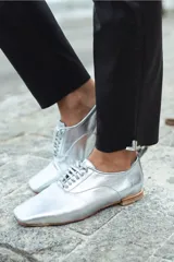 Mocasín acordonado plateado confeccionado en cuero de oveja italiano impermeabilizado. Forrados en cuero con taco de 2,5 cm.