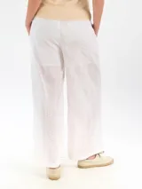 Pantalón ancho color blanco confeccionado en tela broderie con forro interior, de corte recto y tiro medio con cintura elástica.