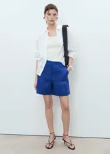 Short azul de lino con tiro medio, bolsillos laterales y diseño recto con cierre oculto.