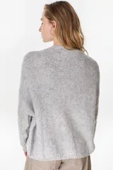 Cardigan tejido de punto gris, de corte relajado, con cuello redondo y cierre frontal de botones.